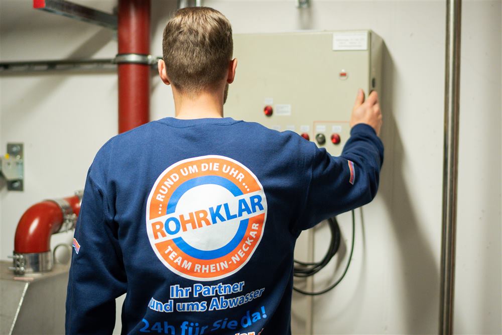 Rohrklar-Team von hinten mit Logo auf der Arbeitskleidung
